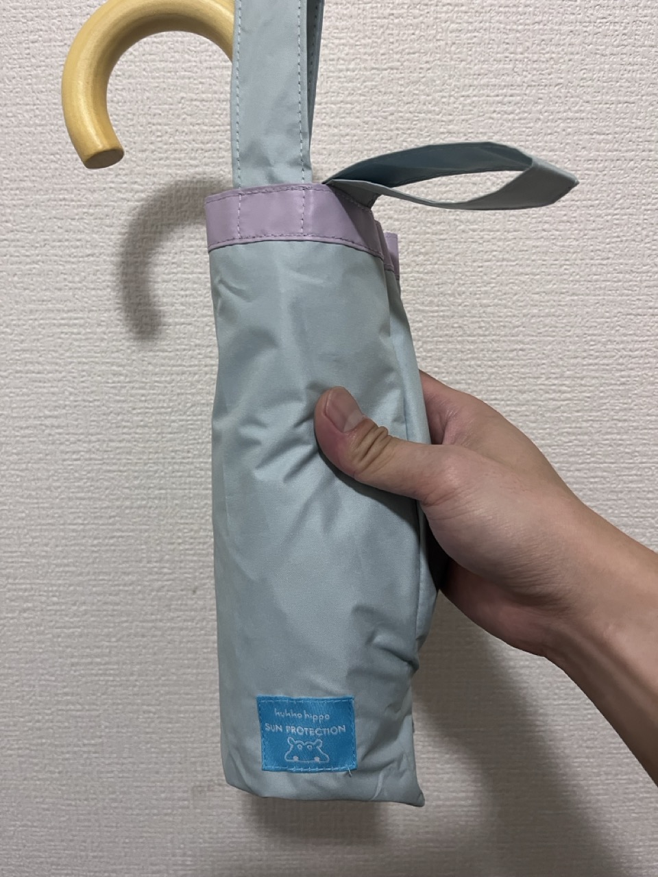 kukka hippoの折りたたみ日傘。たたんだ状態を手に持ったところ